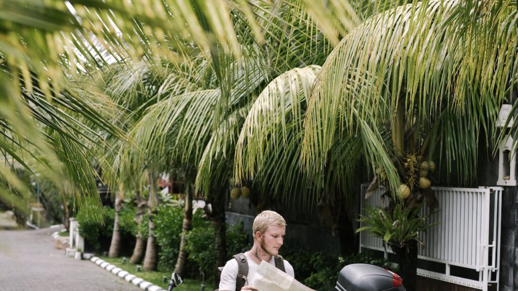 Adult man looking at city map sitting on motorbike on pavement