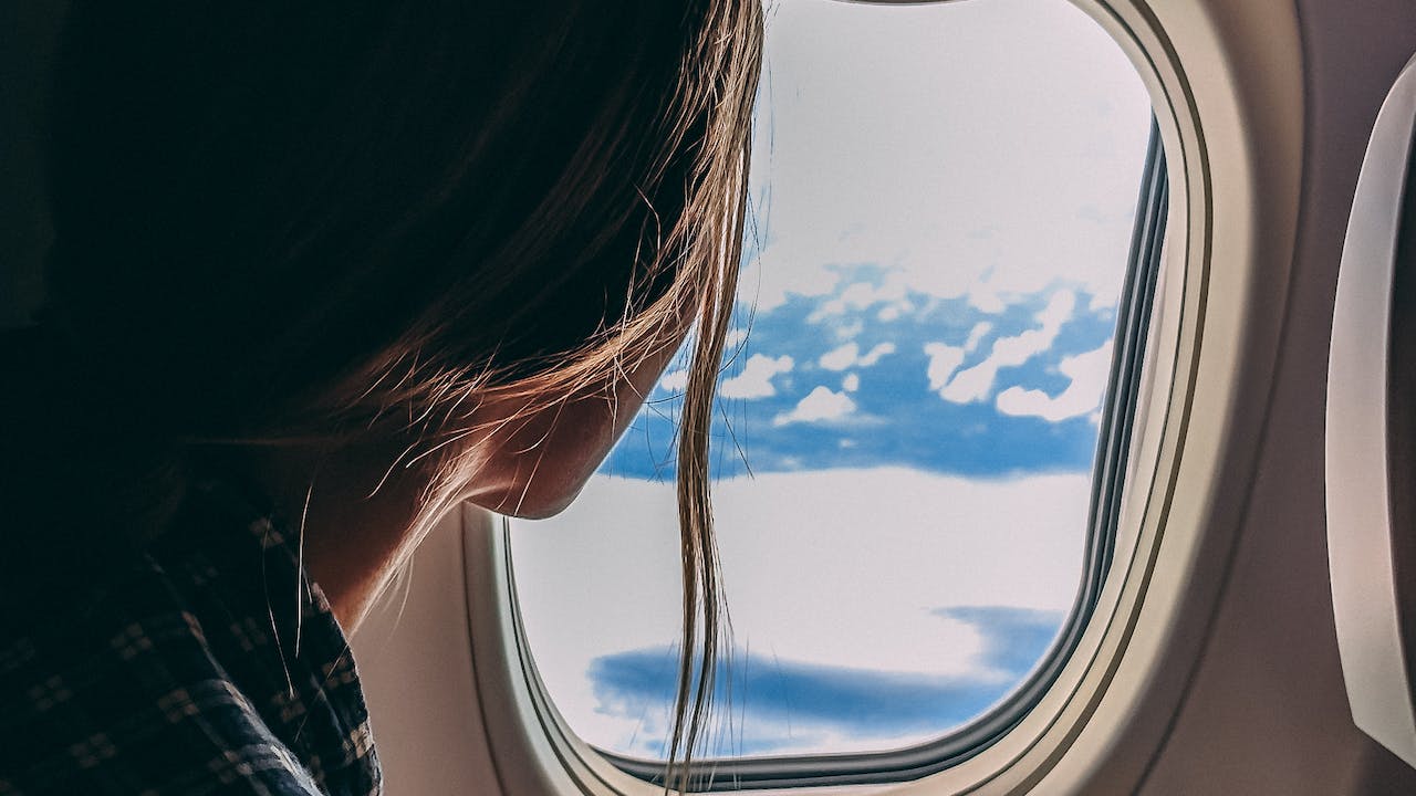 Person holding smartphone riding airplane