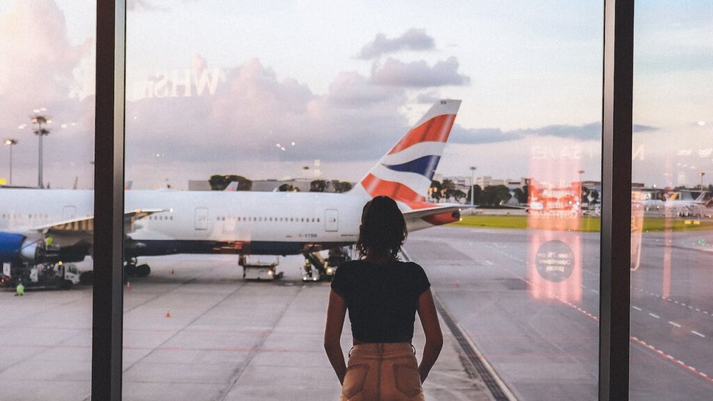 Photo of woman standing near glass wall