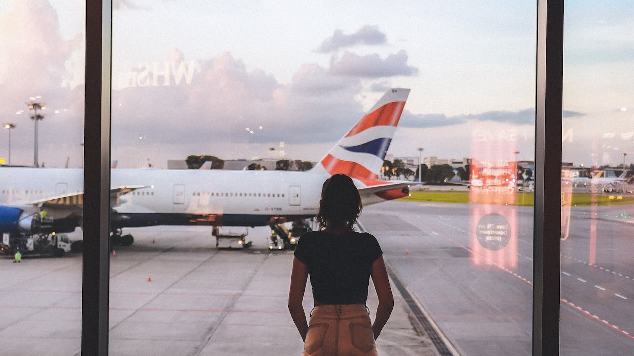 Photo of woman standing near glass wall