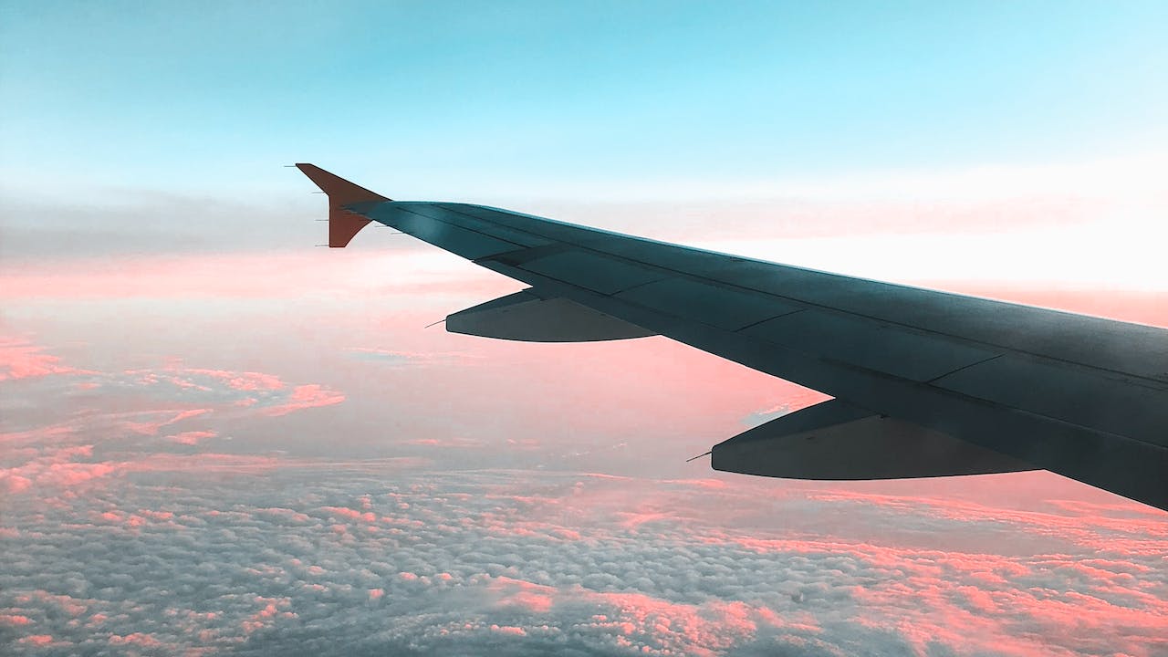 View of airliner wing above the clouds